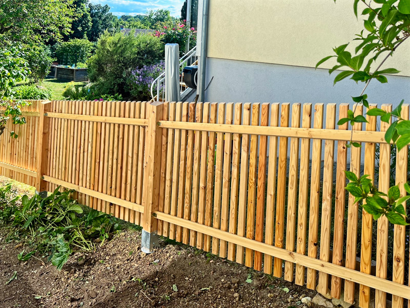 Holzzäune grenzen den Garten auf harmonische und natürliche Weise ein.
